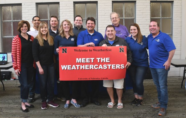 staff members holding a sign that says "meet the weathercasters"